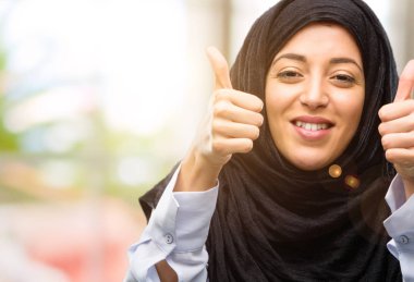 Jest kamera, gibi ifade ve onay için genel olarak gösterilen gülümseyen hijab giyen genç Arap kadın Yaşasın