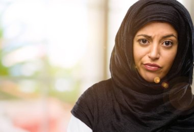 Hijab giyen genç Arap kadın rahatsız ve kızgın negatif duygu ifade, birisi ile rahatsız