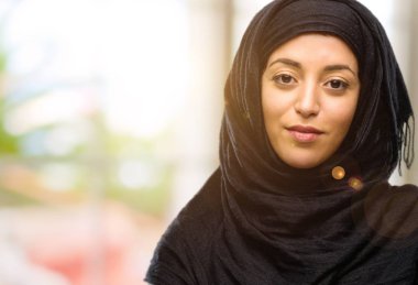 Kendinden emin ve mutlu bir büyük doğal gülümseme gülmek ile çapraz kollu hijab giyen genç Arap kadın