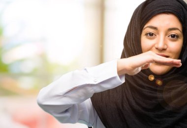 Bir şey, boyut kavramı tutan hijab giyen genç Arap kadın