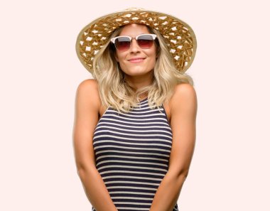 Genç kadın yaz şapka düşünme ve şüphe ve merak ifade seyir güneş gözlüğü kullanarak