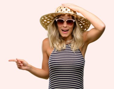 İşaret parmağı ile uzak yan yaz şapka güneş gözlüğü kullanan genç kadın