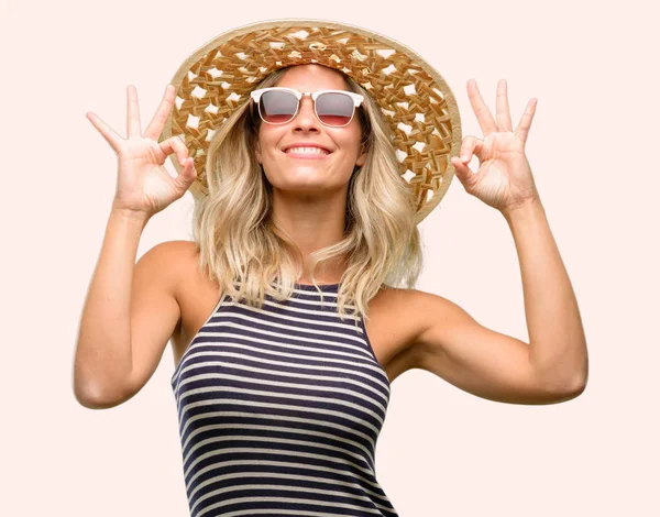 Meditasyon ve gevşeme ifade iki elinle ok işareti jest yapıyor yaz şapka güneş gözlüğü kullanan genç kadın