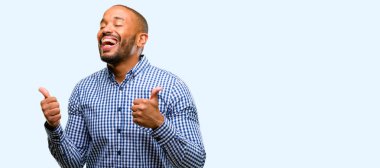 Mavi arka plan üzerinde geniş jest kamera, gibi ifade ve onay için Yaşasın gösterilen sakal gülümseyen Afrikalı-Amerikalı adam izole