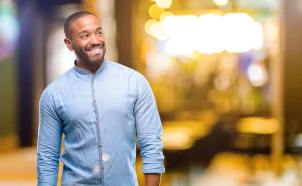 African american man with beard confident and happy with a big natural smile looking side at night