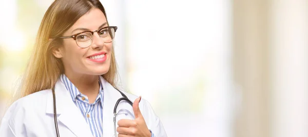 年轻的医生女人 医疗专业的微笑广泛显示大拇指向上手势相机 表达的喜欢和批准 — 图库照片