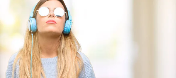 Mujer Joven Escuchar Música Con Auriculares Con Expresión Somnolienta Estar —  Fotos de Stock