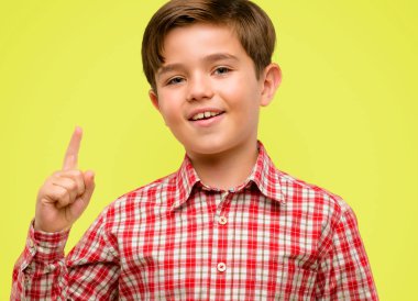 Mutlu ve sarı arka plan üzerinde yukarıyı ifade wow jest tezahürat yeşil gözlü yakışıklı yürümeye başlayan çocuk