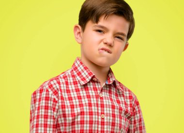 Yeşil gözlü yakışıklı yürümeye başlayan çocuk ifade şüphe, şaşırtmak ve kavramı, sarı arka plan üzerinde belirsiz gelecek merak ediyorum