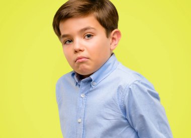 Yeşil gözlü yakışıklı yürümeye başlayan çocuk ifade şüphe, şaşırtmak ve kavramı, sarı arka plan üzerinde belirsiz gelecek merak ediyorum