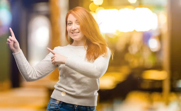 Piękna Młoda Redhead Kobieta Wskazując Drogi Boczne Palcem Nocy — Zdjęcie stockowe