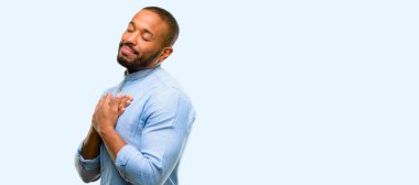 Kalp, elleriyle sakallı Afrikalı-Amerikalı adam sevgi ve sağlık kavramı mavi arka plan üzerinde izole ifade