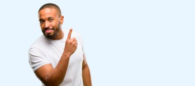 African american man with beard pointing away side with finger isolated over blue background clipart