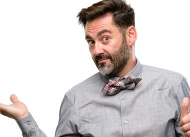 Orta yaş adamla sakal ve papyon başparmak yukarıya bir şey boş elinde tutan ve beyaz arka plan üzerinde izole ok jest yapma