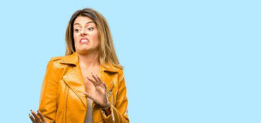 Beautiful young woman disgusted and angry, keeping hands in stop gesture, as a defense, shouting clipart