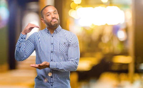 Hombre Afroamericano Con Barba Sosteniendo Algo Concepto Tamaño Noche —  Fotos de Stock