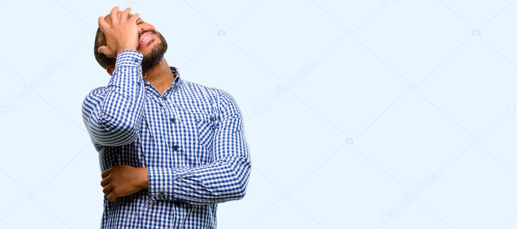 African american man with beard stressful keeping hands on head, tired and frustrated isolated over blue background