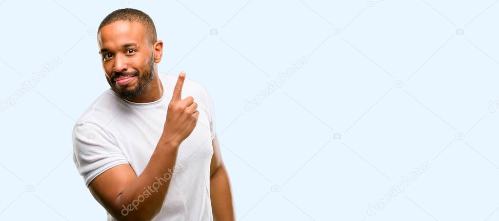 African american man with beard pointing away side with finger isolated over blue background