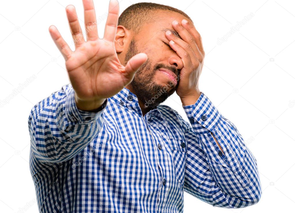 African american man with beard stressful and shy keeping hand on head, tired and frustrated isolated over white background