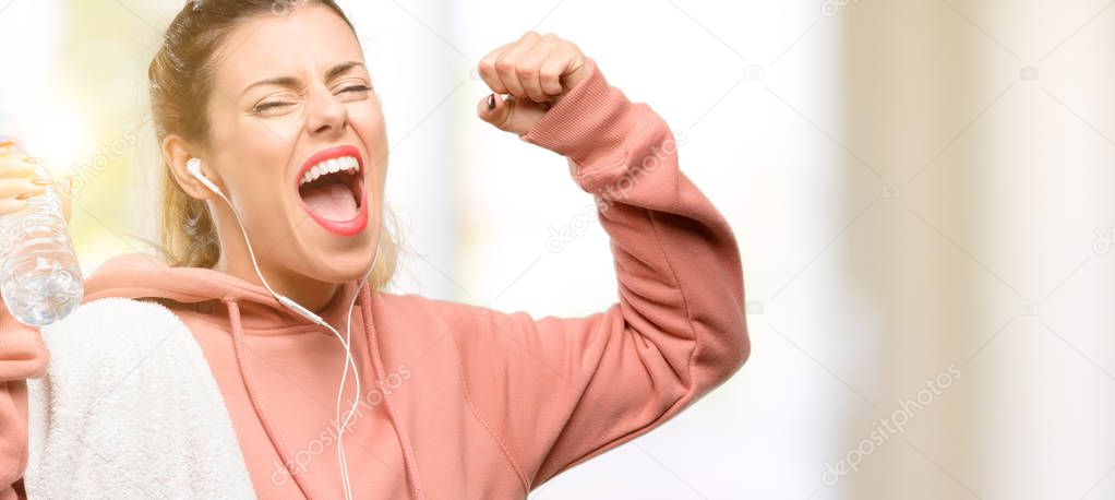 Young sport woman wearing workout sweatshirt happy and excited celebrating victory expressing big success, power, energy and positive emotions. Celebrates new job joyful