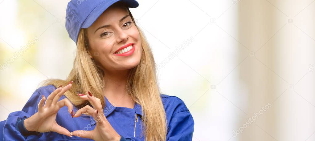 Young plumber woman happy showing love with hands in heart shape expressing healthy and marriage symbol