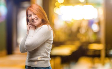 Güzel genç Kızıl saçlı kadın kendinden emin ve mutlu ile büyük bir doğal gülümseme geceleri gülüyor