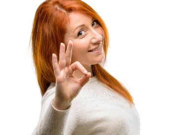 Güzel genç Kızıl saçlı kadının el ile ok işareti yapması onaylama beyaz arka plan üzerinde izole jest