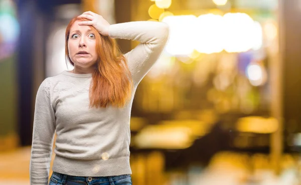 Beautiful young redhead woman terrified and nervous expressing anxiety and panic gesture, overwhelmed at night