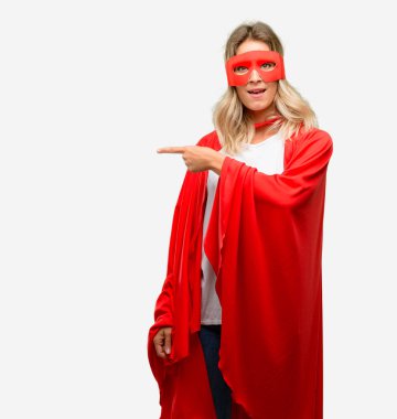 Genç uzak yan parmak ile işaret cape giyen kahraman kadın süper