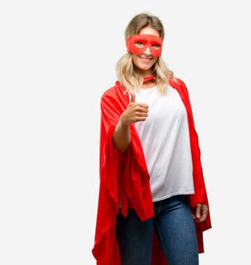 Genç geniş jest kamera, gibi ifade ve onay için Yaşasın gösterilen cape gülümseyen giyen kahraman kadın süper