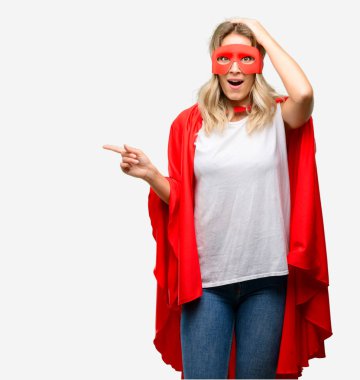 Genç uzak yan parmak ile işaret cape giyen kahraman kadın süper