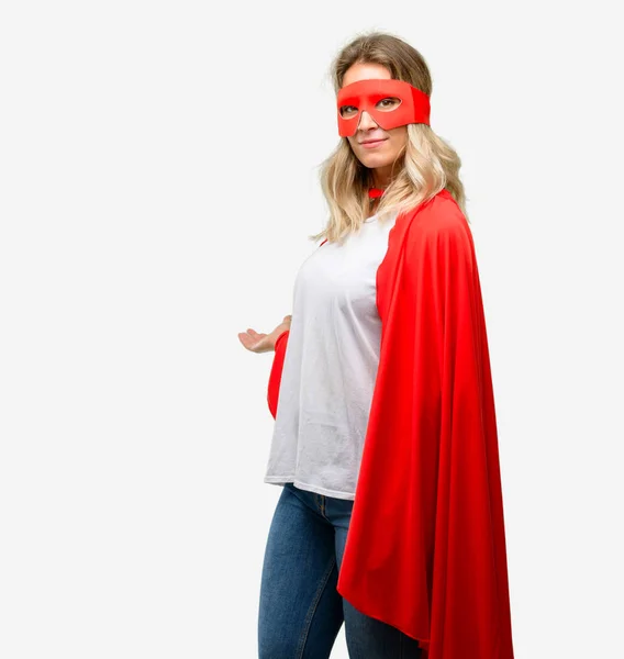 Young super hero woman wearing cape confident and happy with a big natural smile inviting to enter