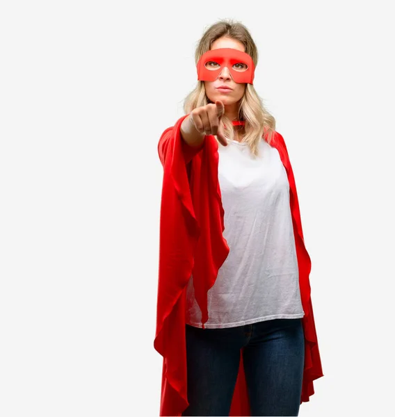 Young super hero woman wearing cape pointing to the front with finger