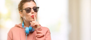 Genç kadın güneş gözlüğü çok korkmuş ve sinir anksiyete ve panik jest, bunalmış ifade etmek ve kulaklık ile spor