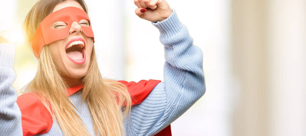 Young super woman happy and excited celebrating victory expressing big success, power, energy and positive emotions. Celebrates new job joyful