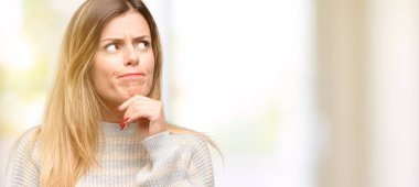 Genç, güzel bir kadın, düşünüyor, yukarı bakıyor şüphe ve merakını dile getiriyor.