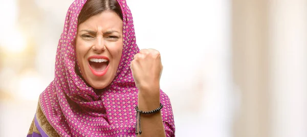 Young arab woman wearing hijab irritated and angry expressing negative emotion, annoyed with someone