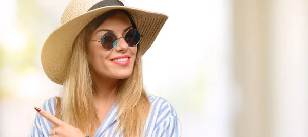 Mujer Joven Con Gafas Sol Sombrero Verano Apuntando Hacia Lado —  Fotos de Stock