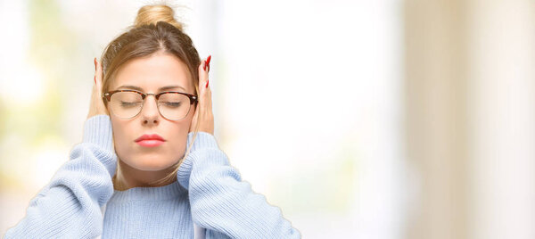 Young woman shop owner, wearing apron covering ears ignoring annoying loud noise, plugs ears to avoid hearing sound. Noisy music is a problem.