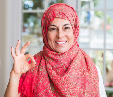 Orta parmak, mükemmel sembolü ile ok işareti yapıyor hijab giyen Müslüman kadın yaşlı