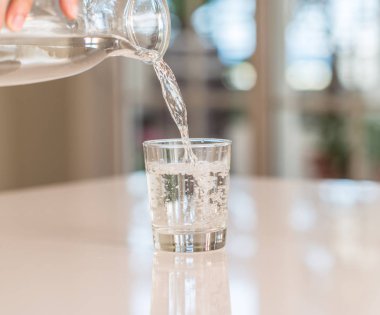 Dalış bir cam ile güneşli bokeh arka plan evde masaya dökülen şişe closeup.