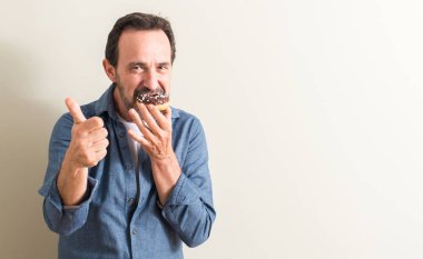 Komuta sizde ok işareti, başparmak ile parmak, mükemmel işareti yapıyor kocaman bir gülümseme ile çikolatalı çörek mutlu yemek