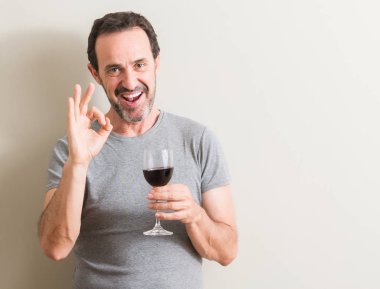 Komuta sizde parmak, mükemmel sembolü ile ok işareti yapıyor bir bardak kırmızı şarap içme