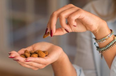 Eller genç kadın mutfağa holding fıstık. Yakın çekim. Sağlıklı kavramı.