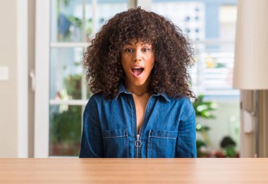 Afrikalı-Amerikalı kadın evde korkuyor şok sürpriz yüz, korkuyor ve heyecanlı korku ifadesi ile