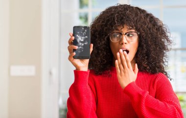 Afrikalı-Amerikalı kadın kırık holding smartphone kapak ağız elle hata, korku, sessizlik içinde gizli kavramı korkmuş ifade için utanç ile şok