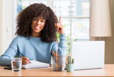 Afrikalı-Amerikalı kadın bilgisayar dizüstü kullanarak evde eğitim bir fikir ya da soru işaret parmağı gülen yüz, bir numara ile şaşırttı