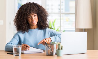 Afrikalı-Amerikalı kadın eğitimi evde bir bilgisayar dizüstü el ve parmak ile işaret çok mutlu kullanma