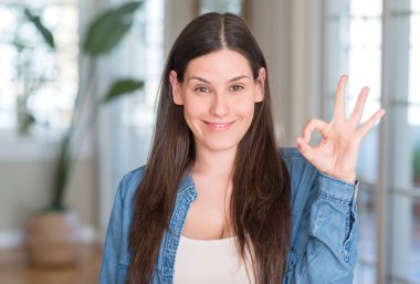 Genç güzel kadın evde parmak, mükemmel sembolü ile ok işareti yapıyor