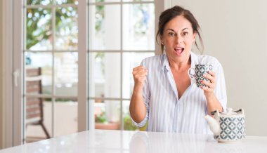 Bir fincan çay ya da gurur çığlık ve zafer ve başarı çok heyecanlı, kutluyor kahve içme kadın duygu tezahürat orta yaşlı